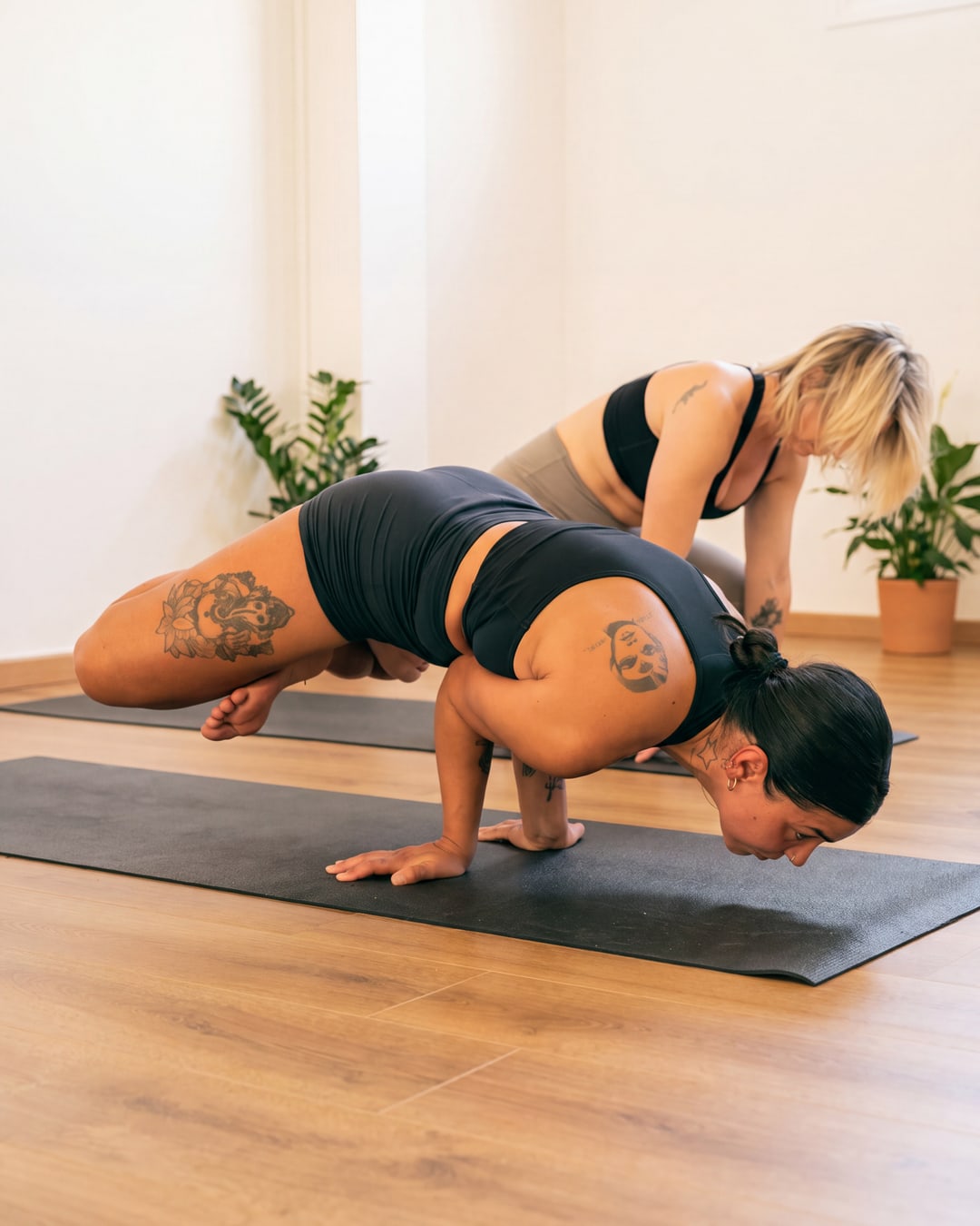 Studentessa in bakasana, la posa del corvo, sul tappetino.